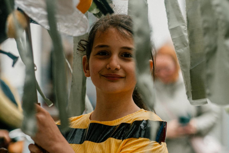 Een meisje van gemeentelijke basisschool Evergem houdt een paraplu met bij erop omhoog