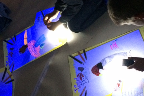 Kinderen tekenen met fluostift onder blacklight