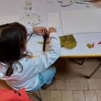 Een deelnemer aan de workshop schikt haar verzamelde natuurmaterialen in de vorm van een figuurtje